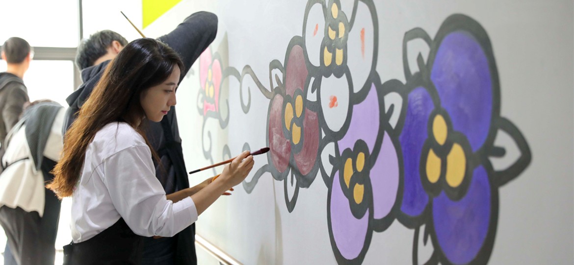 group of students painting a mural