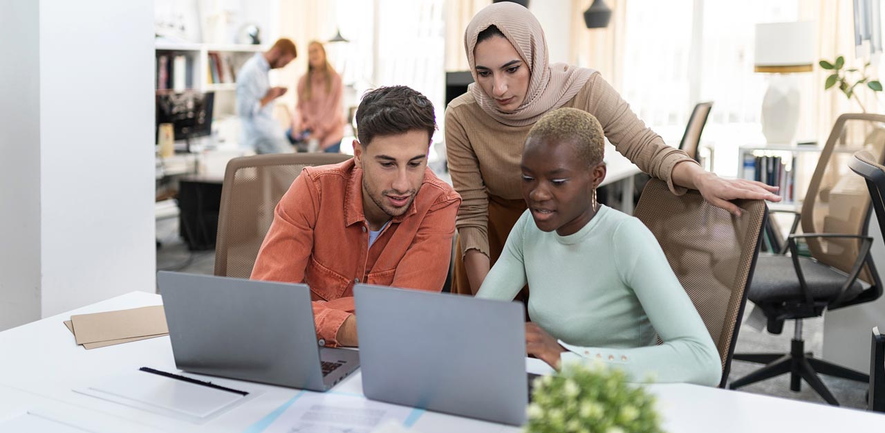coworkers meeting in office with laptops